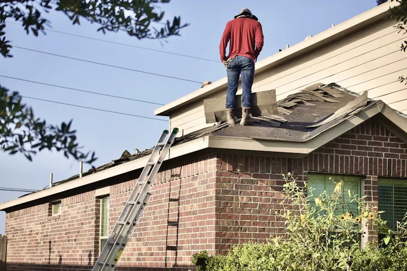 Professional roofer working on a residential roof in Clovis